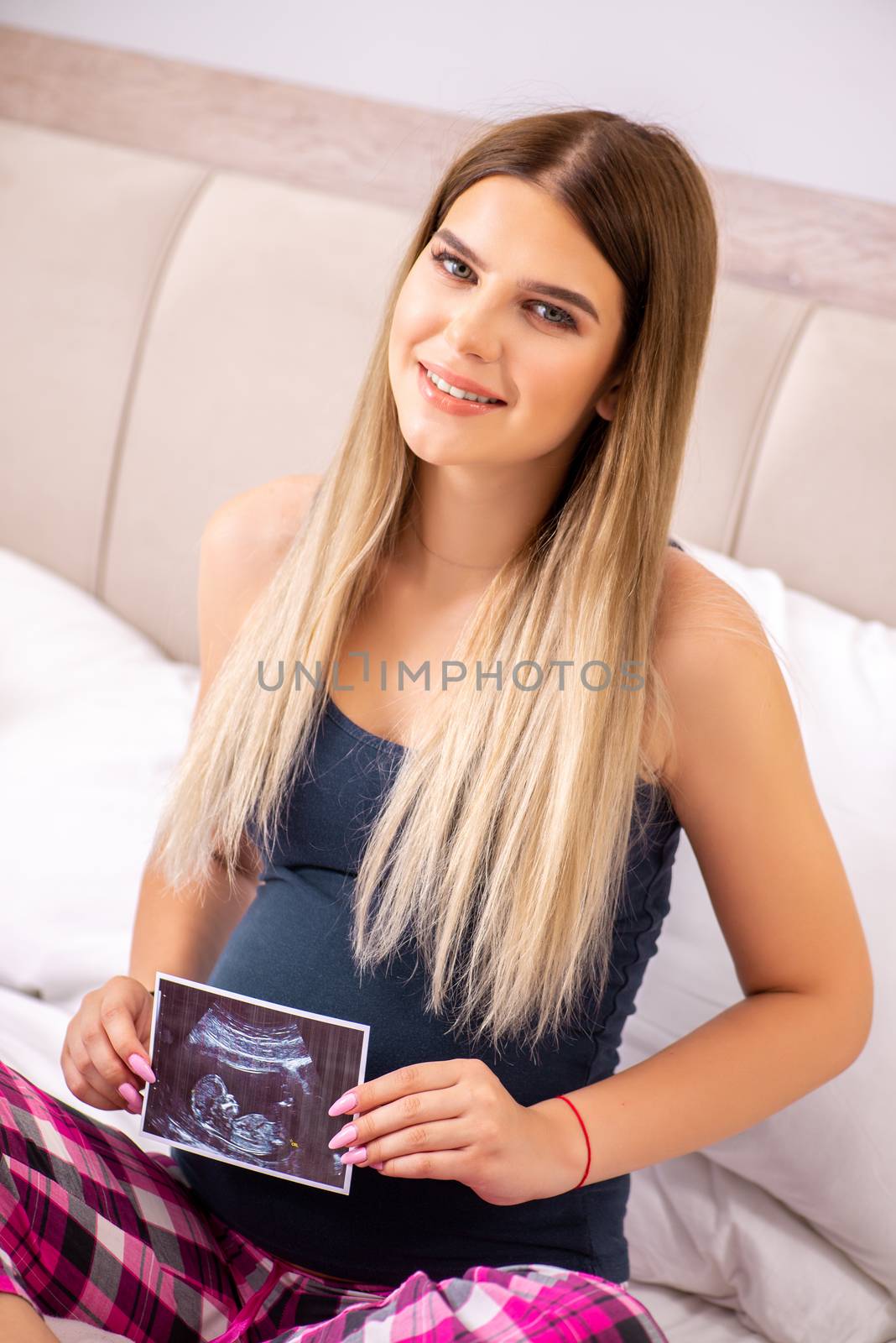 Happy young pregnant woman in the bed
