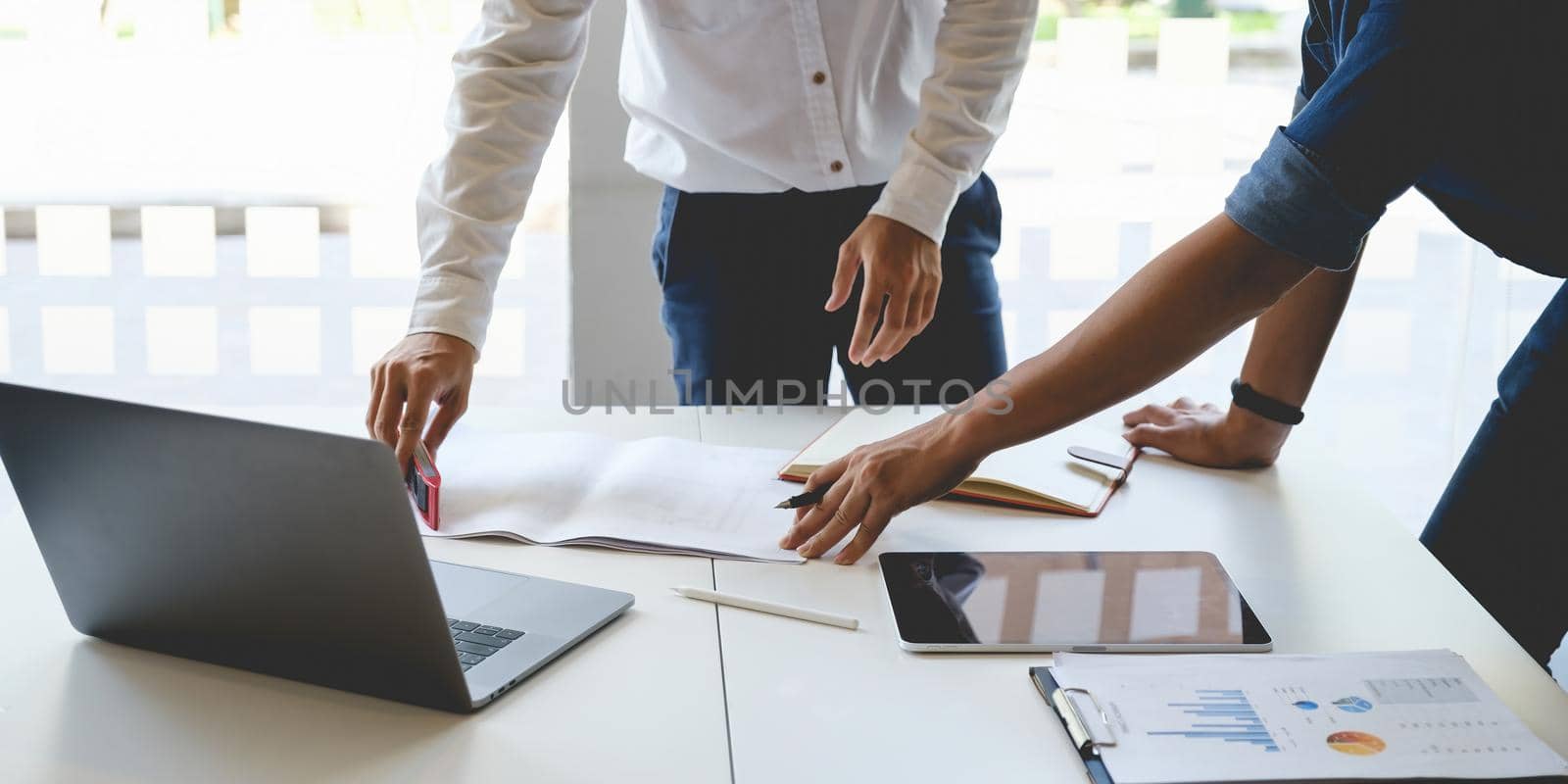 Two Architect man working with laptop and blueprints for architectural plan, engineer sketching a construction project concept