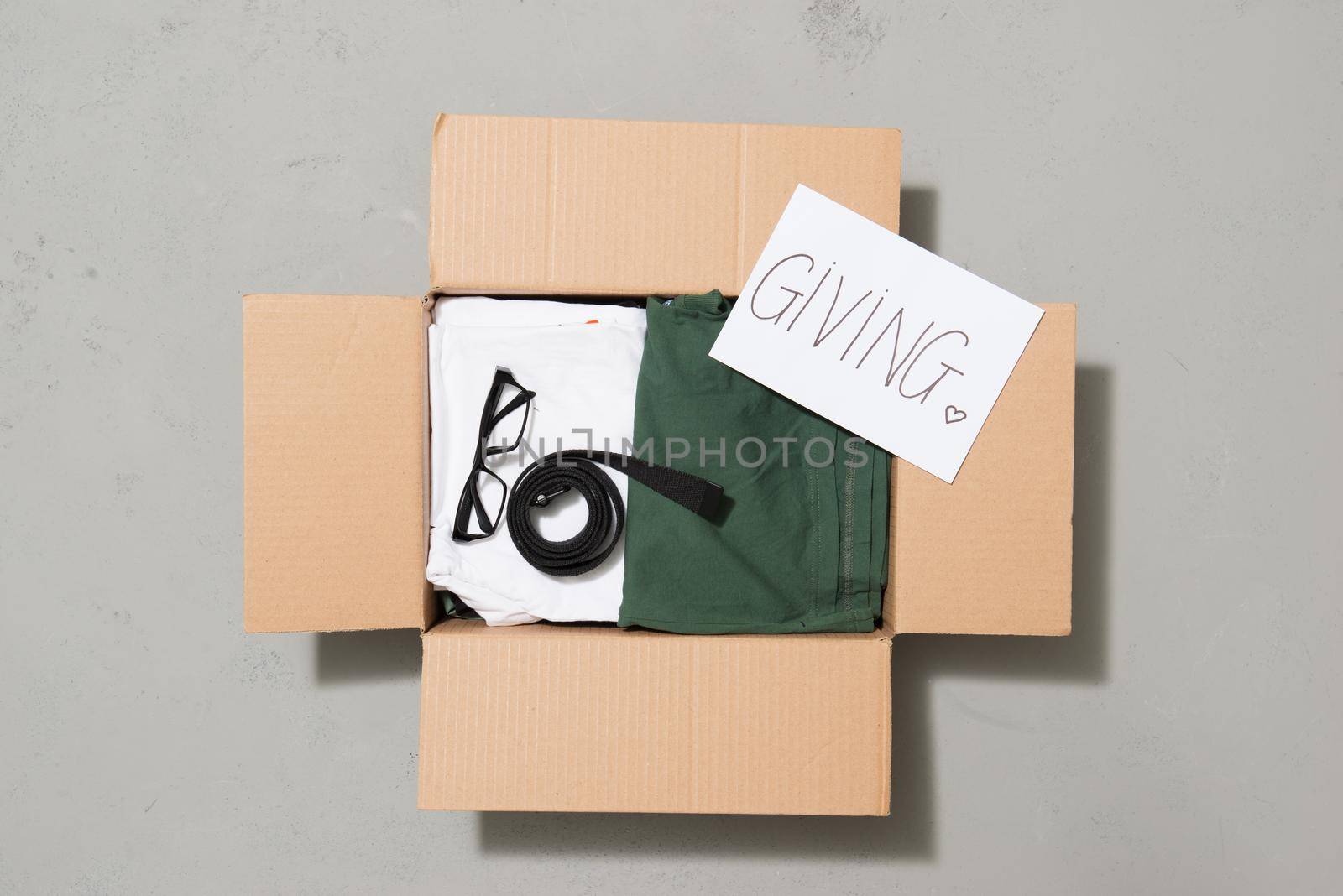 Donation box with clothes isolated on gray by makidotvn