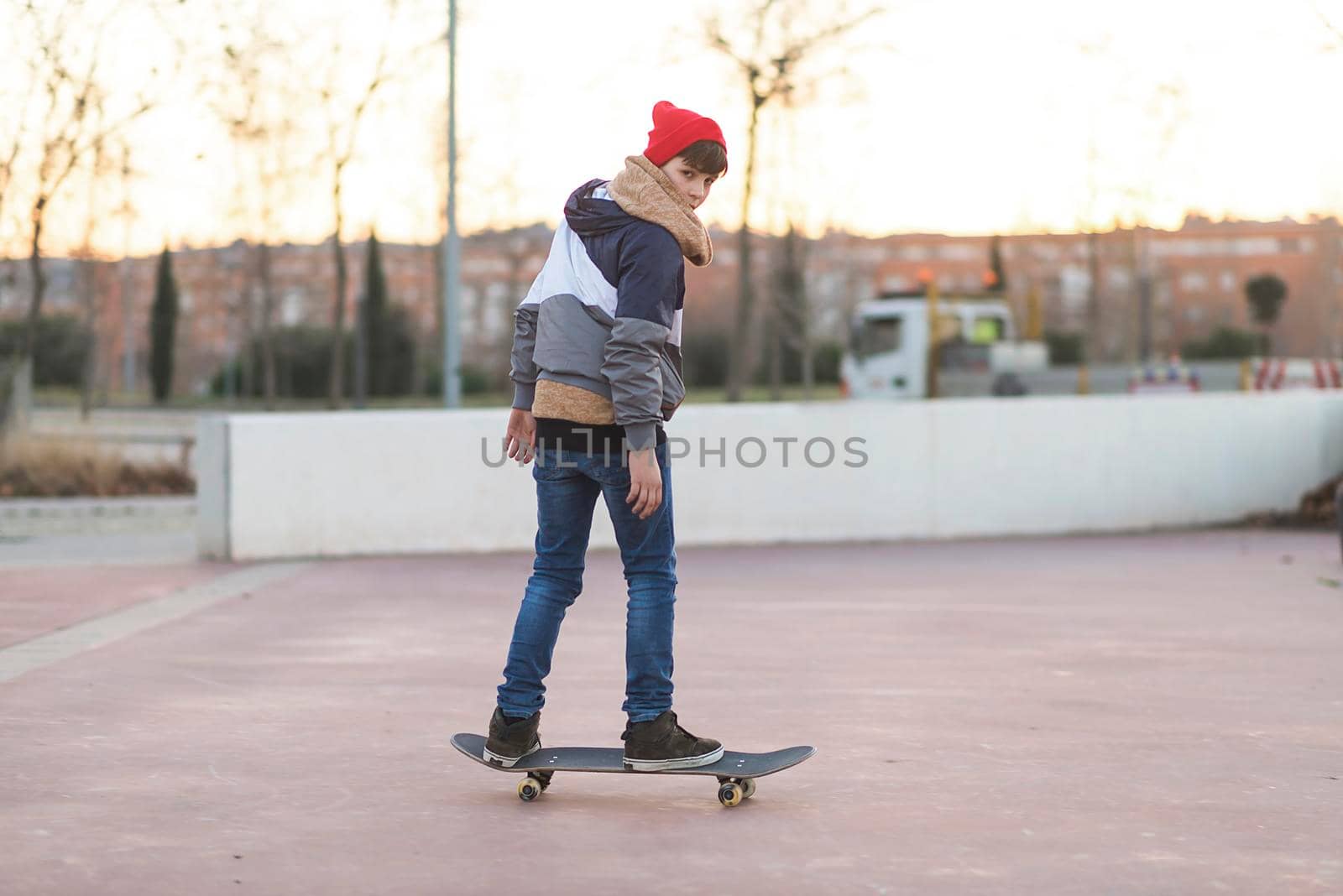 Teenager skateboarder boy with a skateboard on asphalt playground doing tricks. by raferto1973