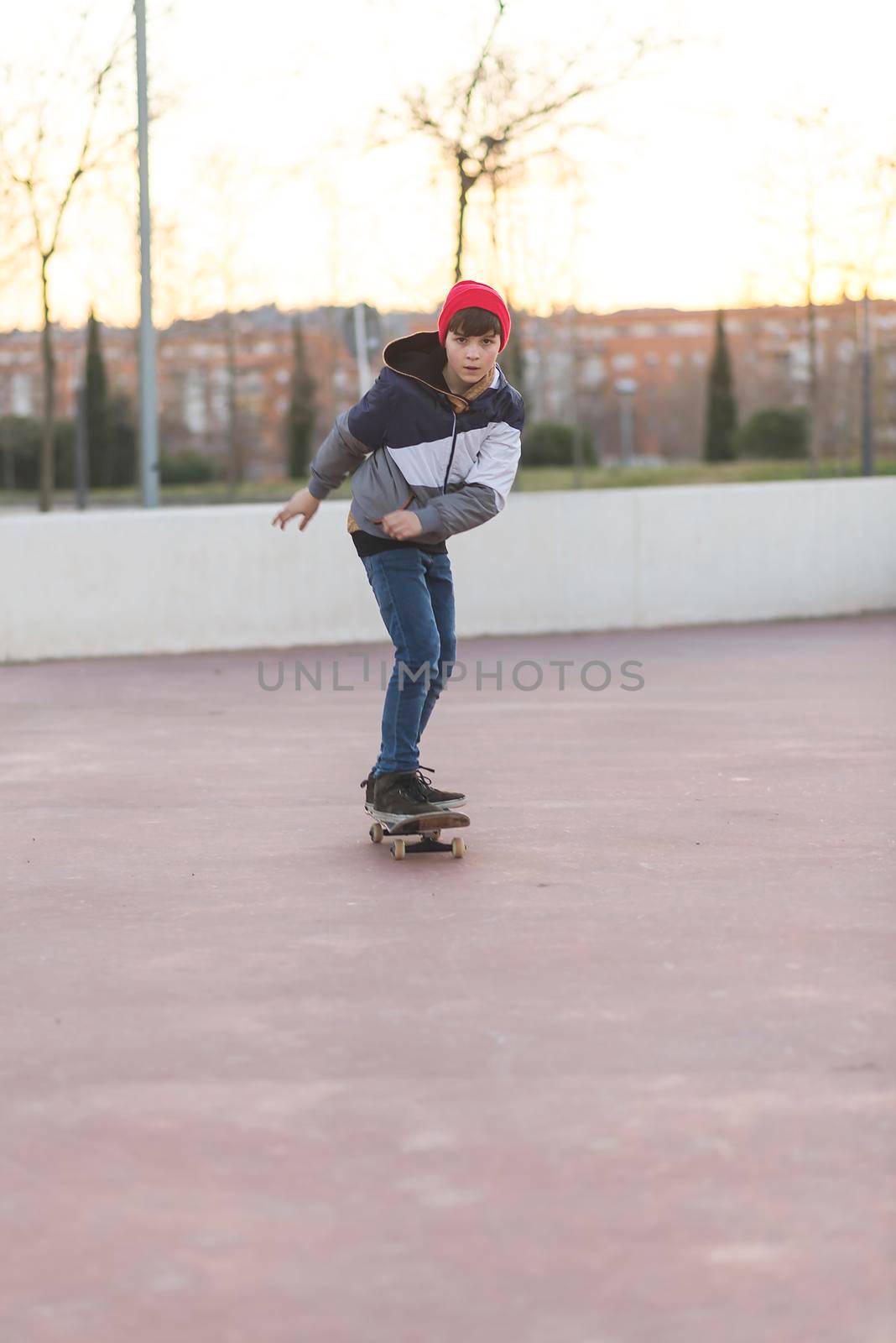 Teenager skateboarder boy with a skateboard on asphalt playground doing tricks. by raferto1973