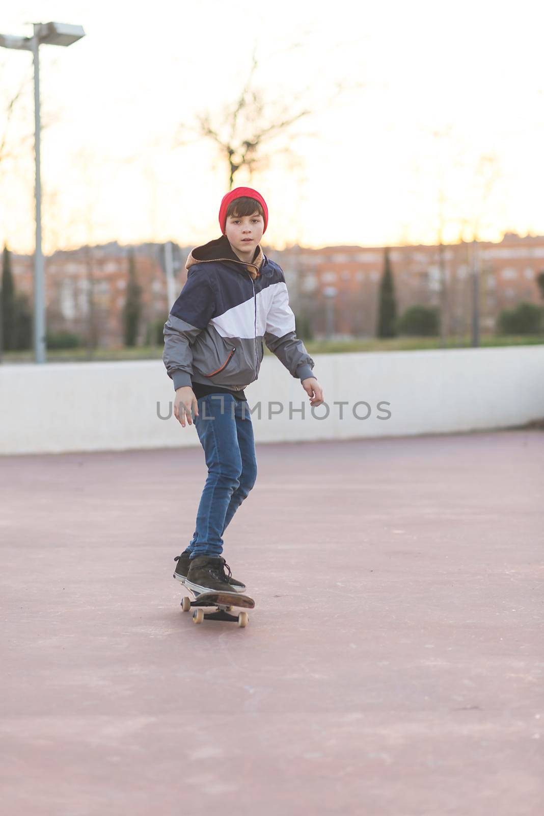 Teenager skateboarder boy with a skateboard on asphalt playground doing tricks. by raferto1973