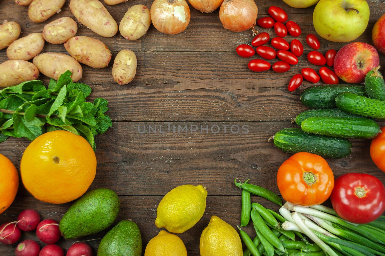 Flexitana diet concept.Composition with assorted fresh organic vegetables and fruits.Place for text.Cucumbers,tomatoes,radish, avocado, peas,potatoes,lemon,onions.Food on dark wooden background.