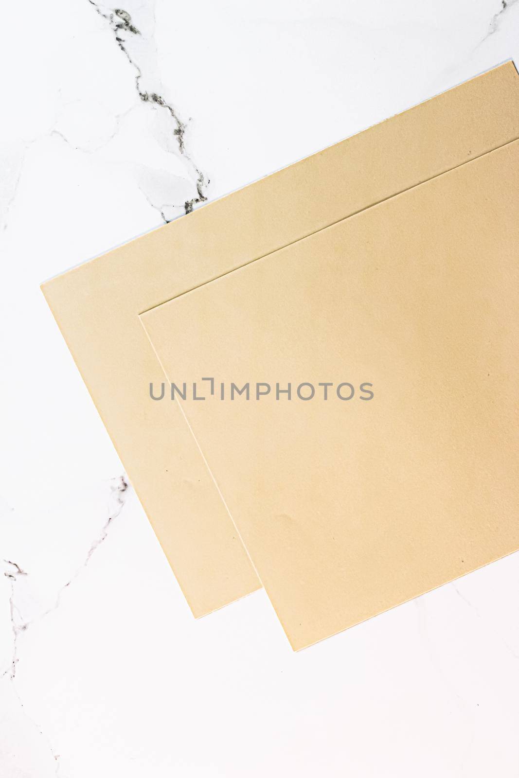 Beige A4 papers on white marble background as office stationery flatlay, luxury branding flat lay and brand identity design for mockup by Anneleven