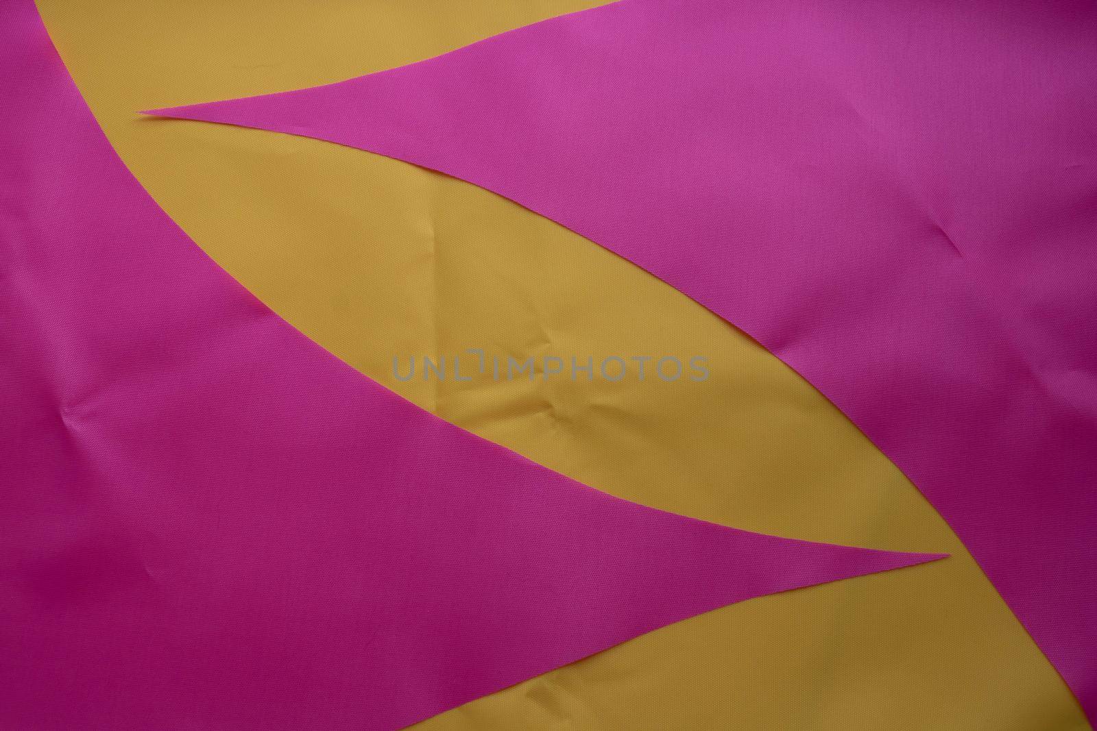 Pink pieces of fabric lie on the yellow fabric.