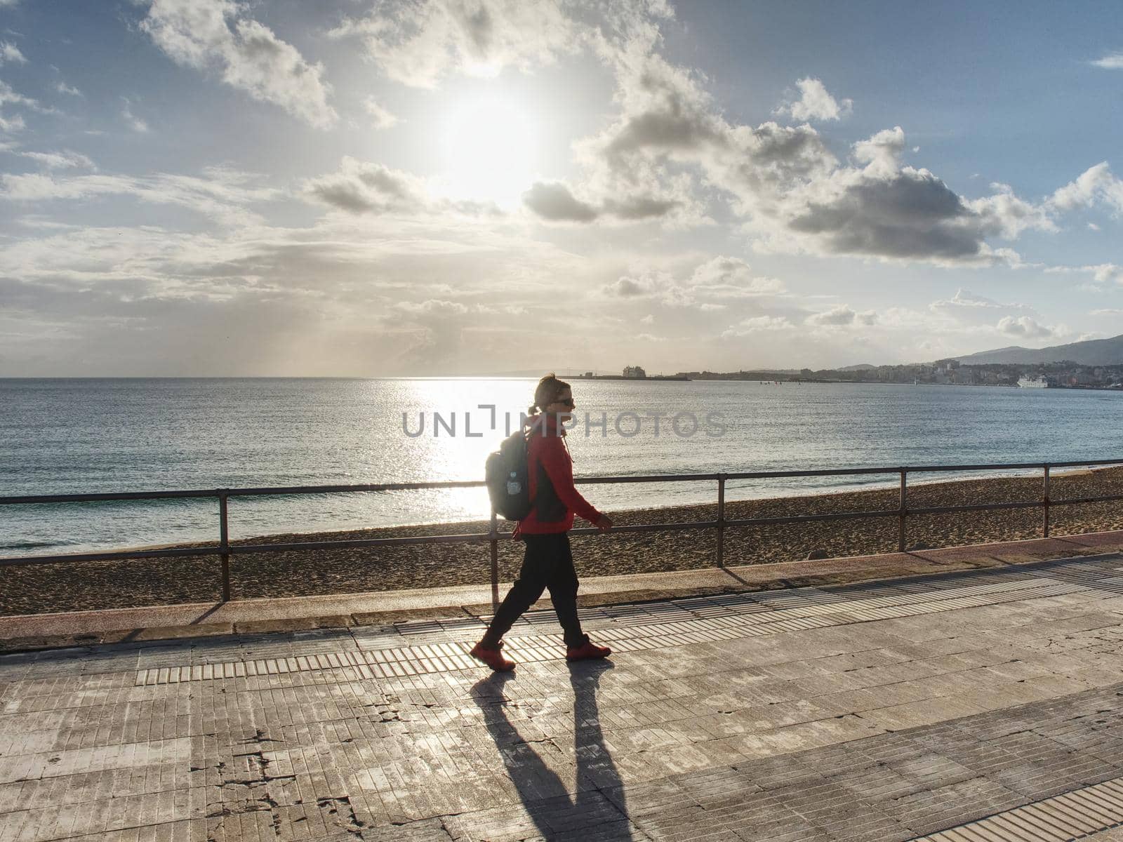 Female backpacker walk or strolling along beach  by rdonar2