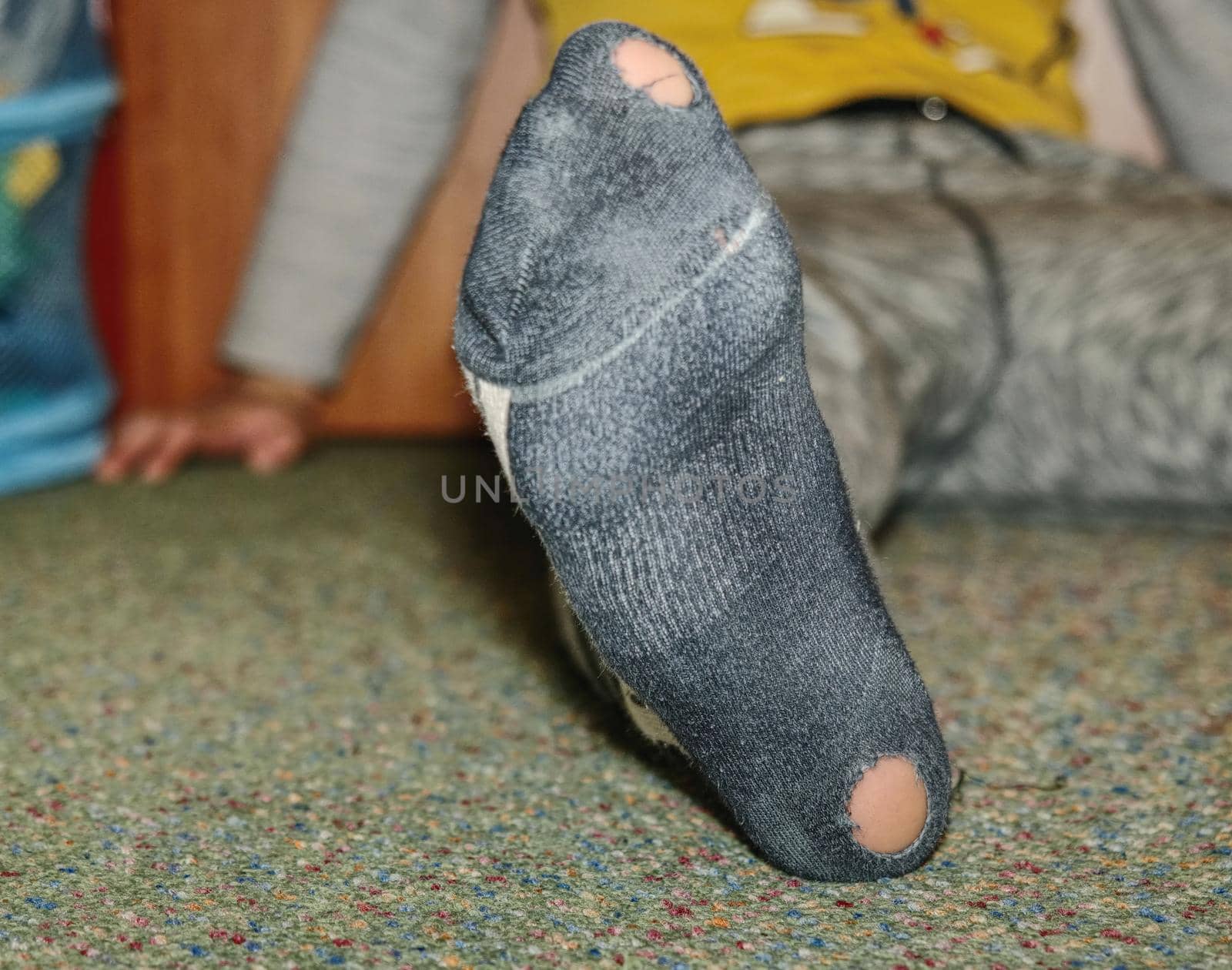 Worn socks with a hole and heel sticking out. Old worn clothes