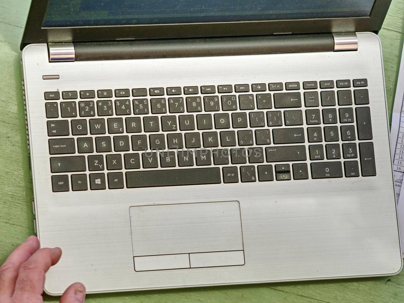Old hands with wrinkles typing on laptop. Modern old pensioner working from home. Close up view of elderly woman's hands