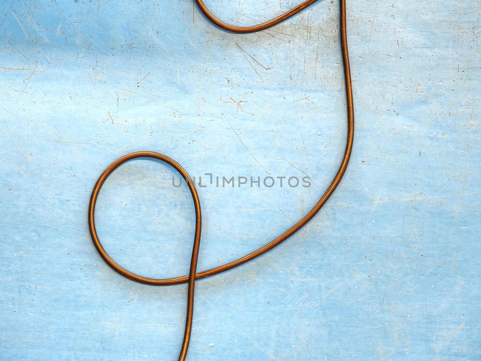 Blackcharging cable in form as love shape cable on  blue wooden floor