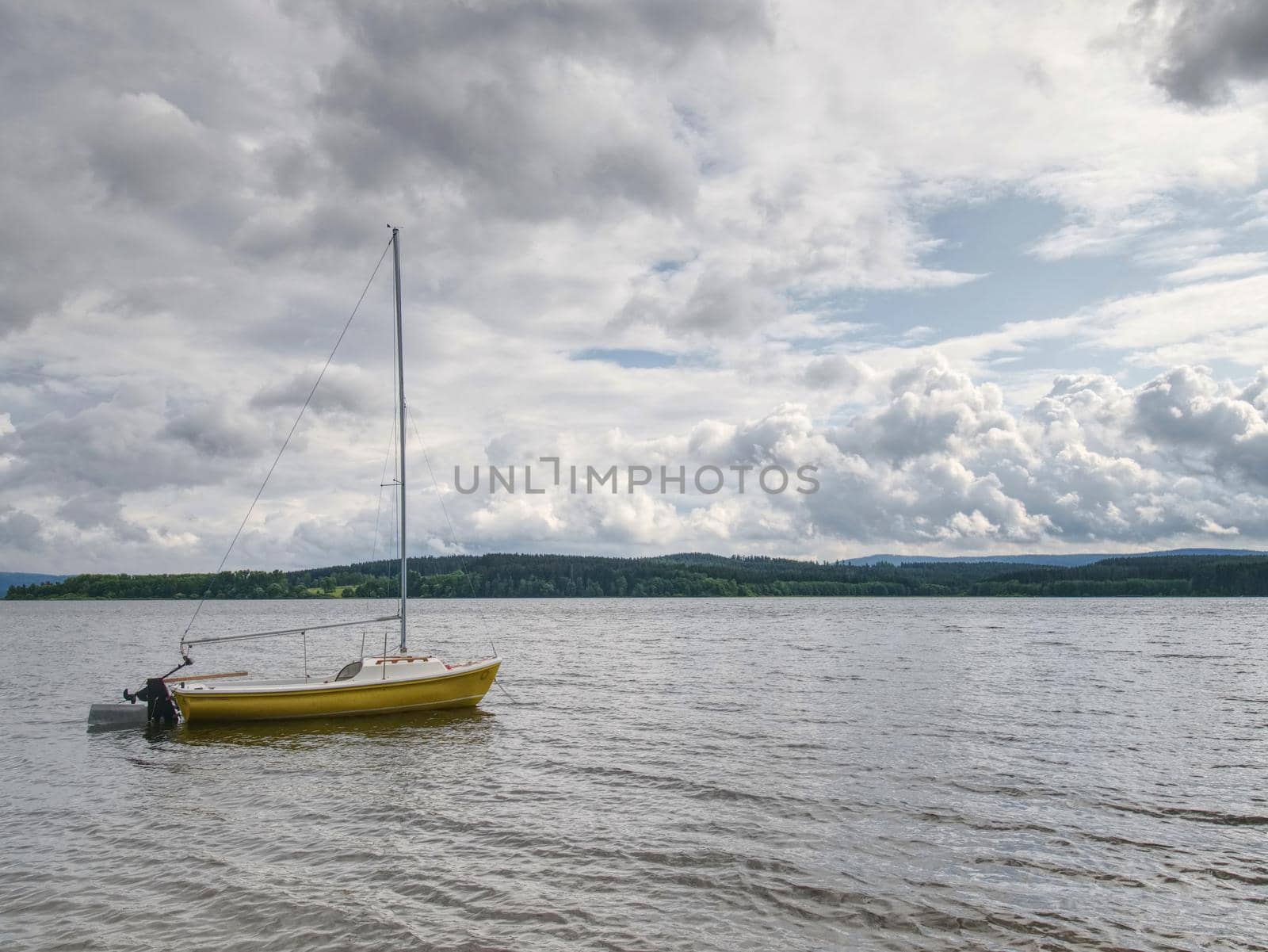 Boat anchored in calm bay. Touristic resort with nobody.  Calm water level, idilic walk at shore.