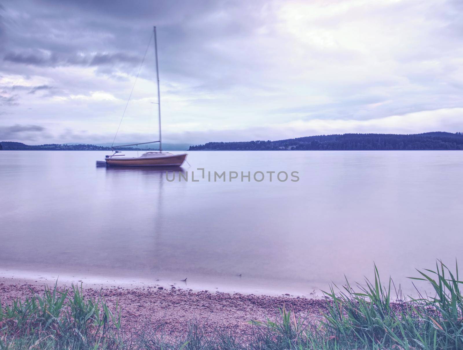 Boat on calm water. Yacht on water near the coast. Empty yacht and blue silent water
