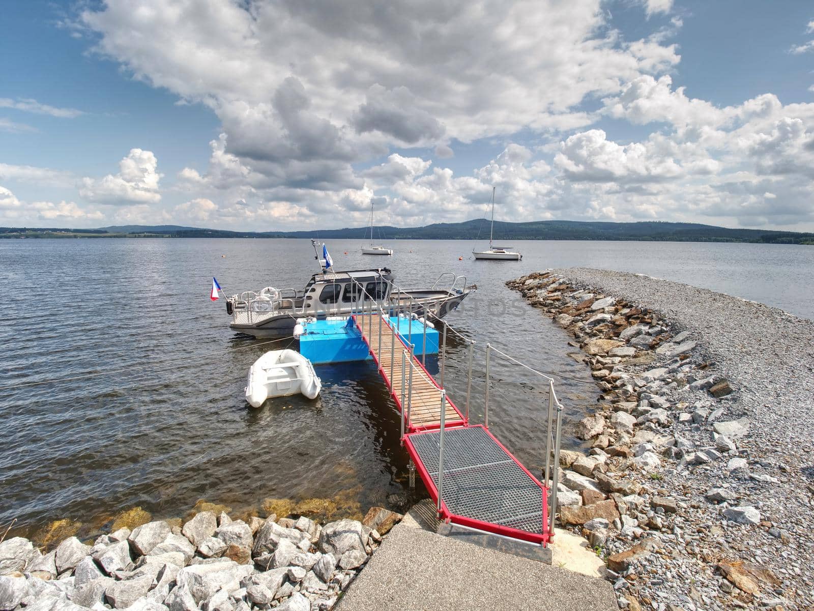 Small boat at the steel pier on the river or lake. Travel and recreation, sunny weather forecast