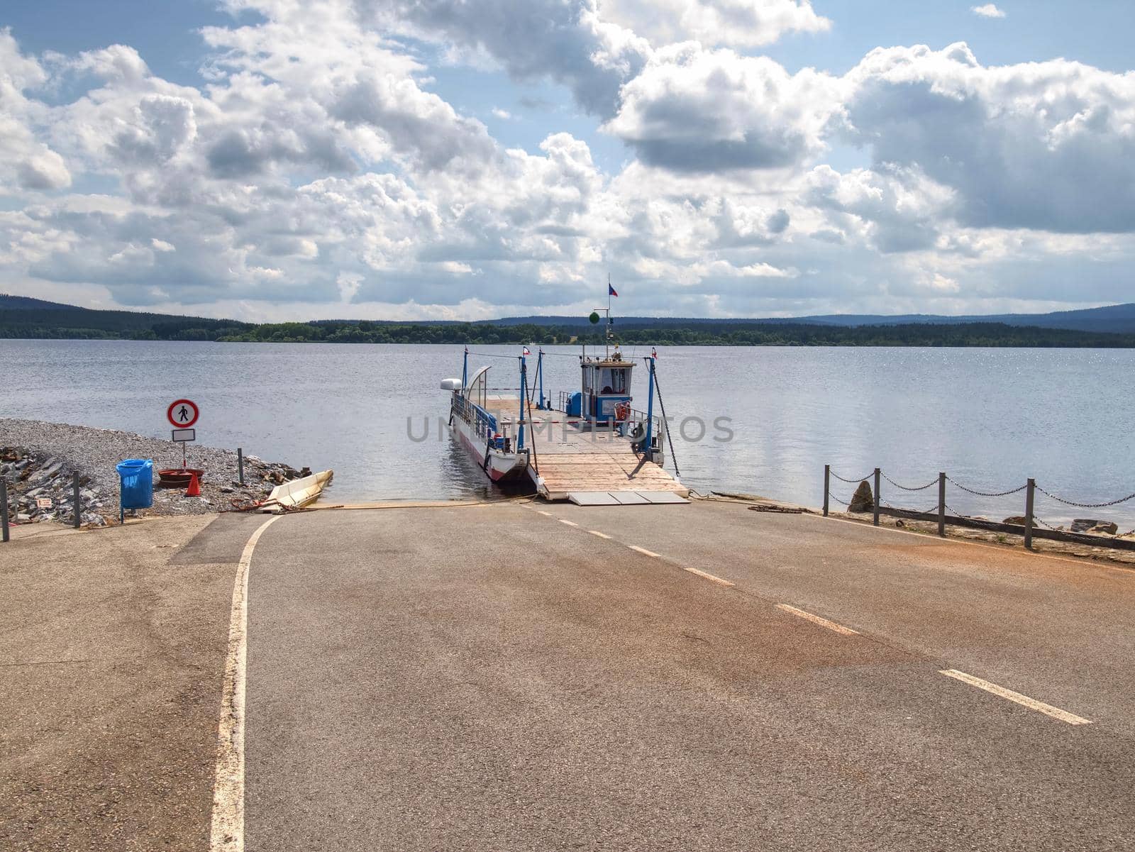 View over ferry metal boat against the wavy lake water and a blue sky