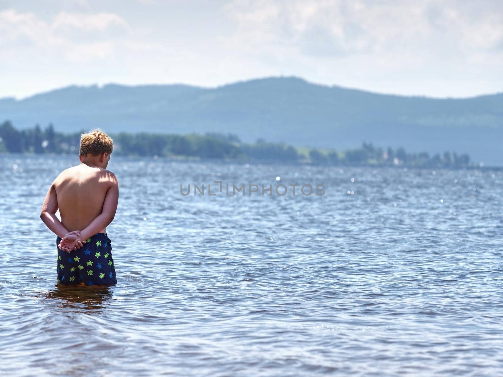 Kid stay in cold spring lake ant test cold water in sunny weather.  by rdonar2