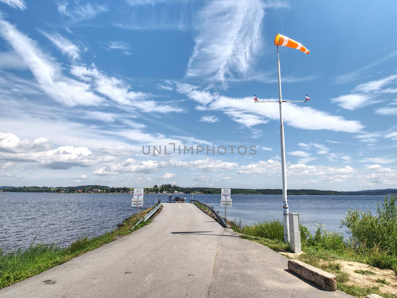 Ferry pier with windsock at the shore of Lipno lake, gentle wind by rdonar2