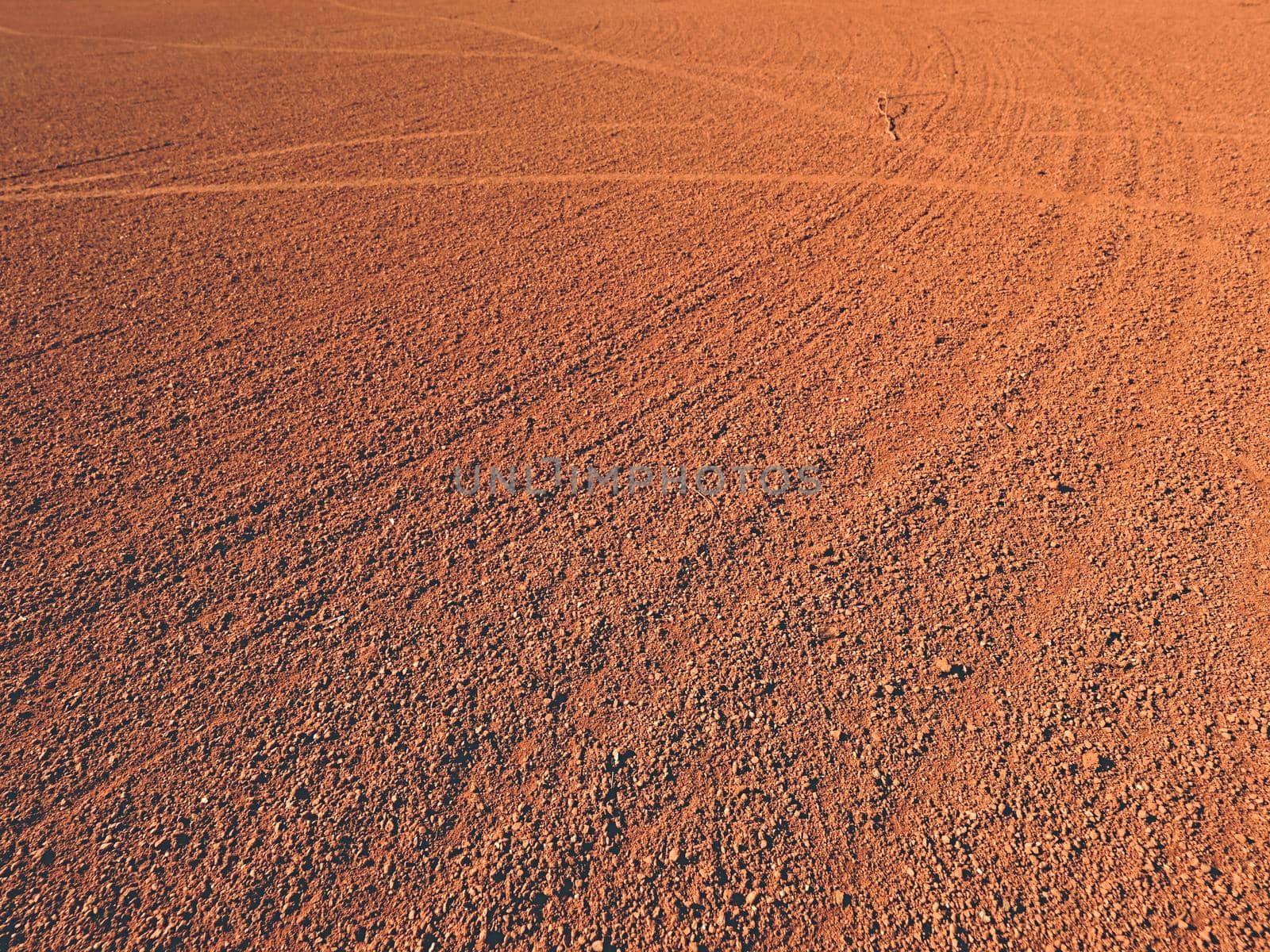 Dry light red crushed bricks surface on outdoor tennis playground court 