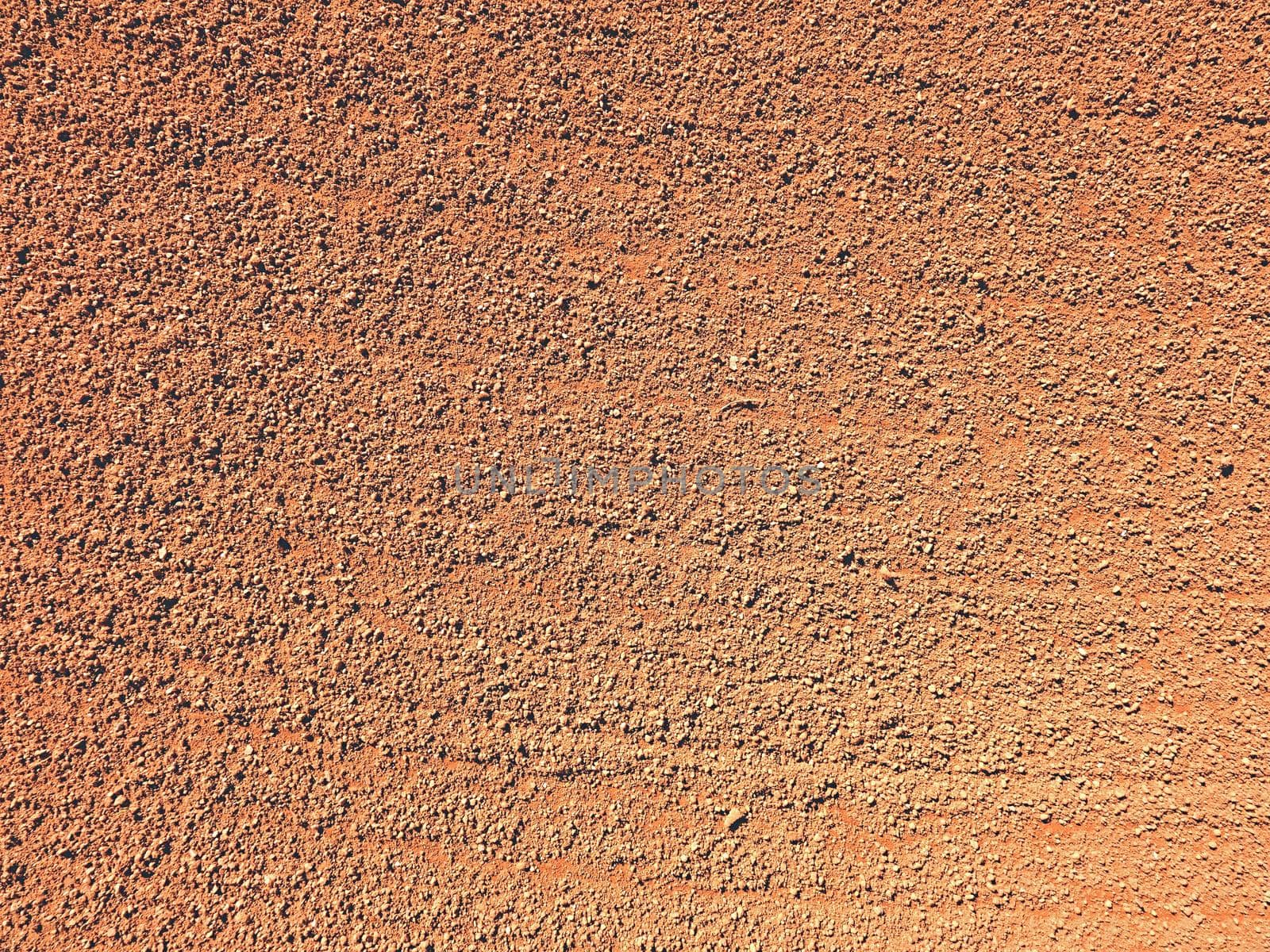 Dry light red crushed bricks surface on outdoor tennis playground court 