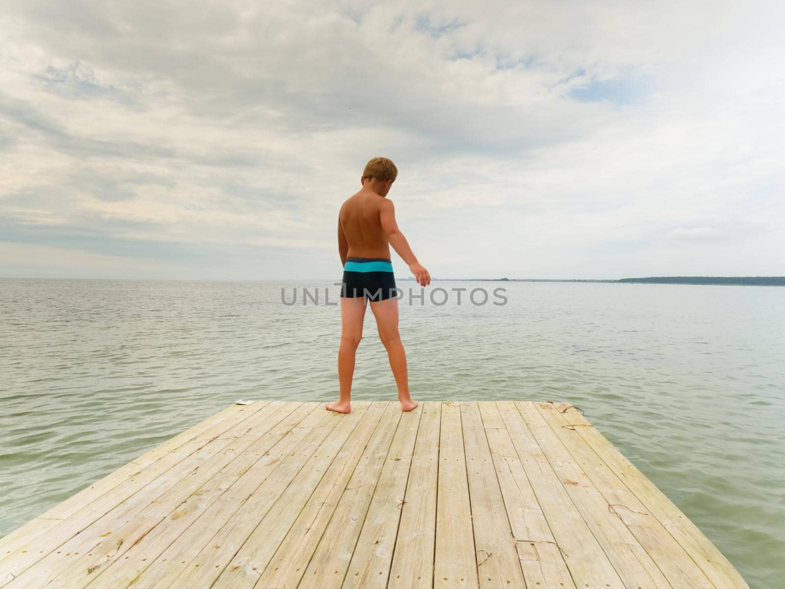 Tranquil peaceful lake with jetty. Iron ladder for passangers and swimmers. Blurred board because long exposure.