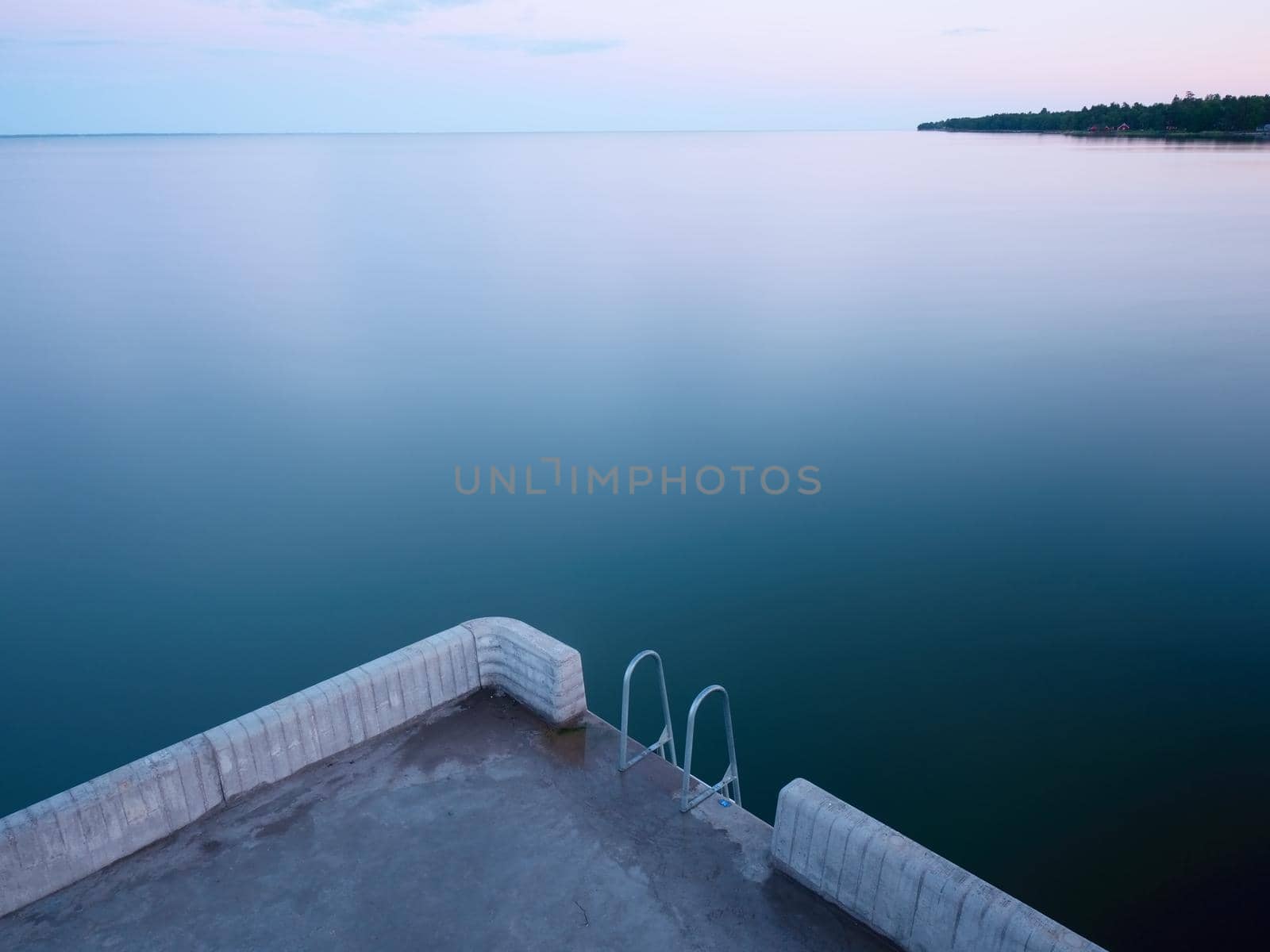 Swimming mole. Handrails and hanged ladder at the end of sea pier