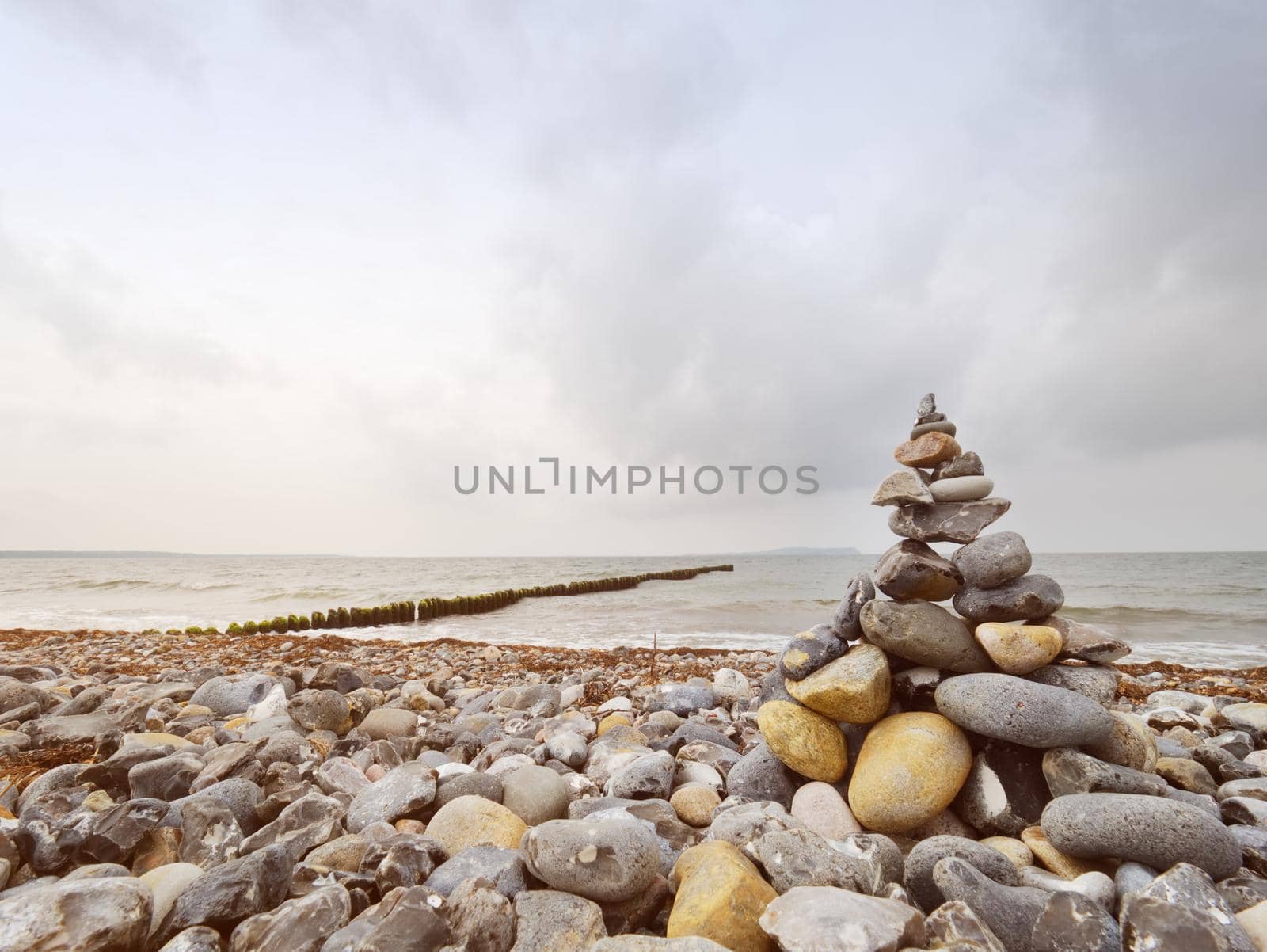 Pyramid of sea stones on pebbles of the sea shore. Seascape.  by rdonar2