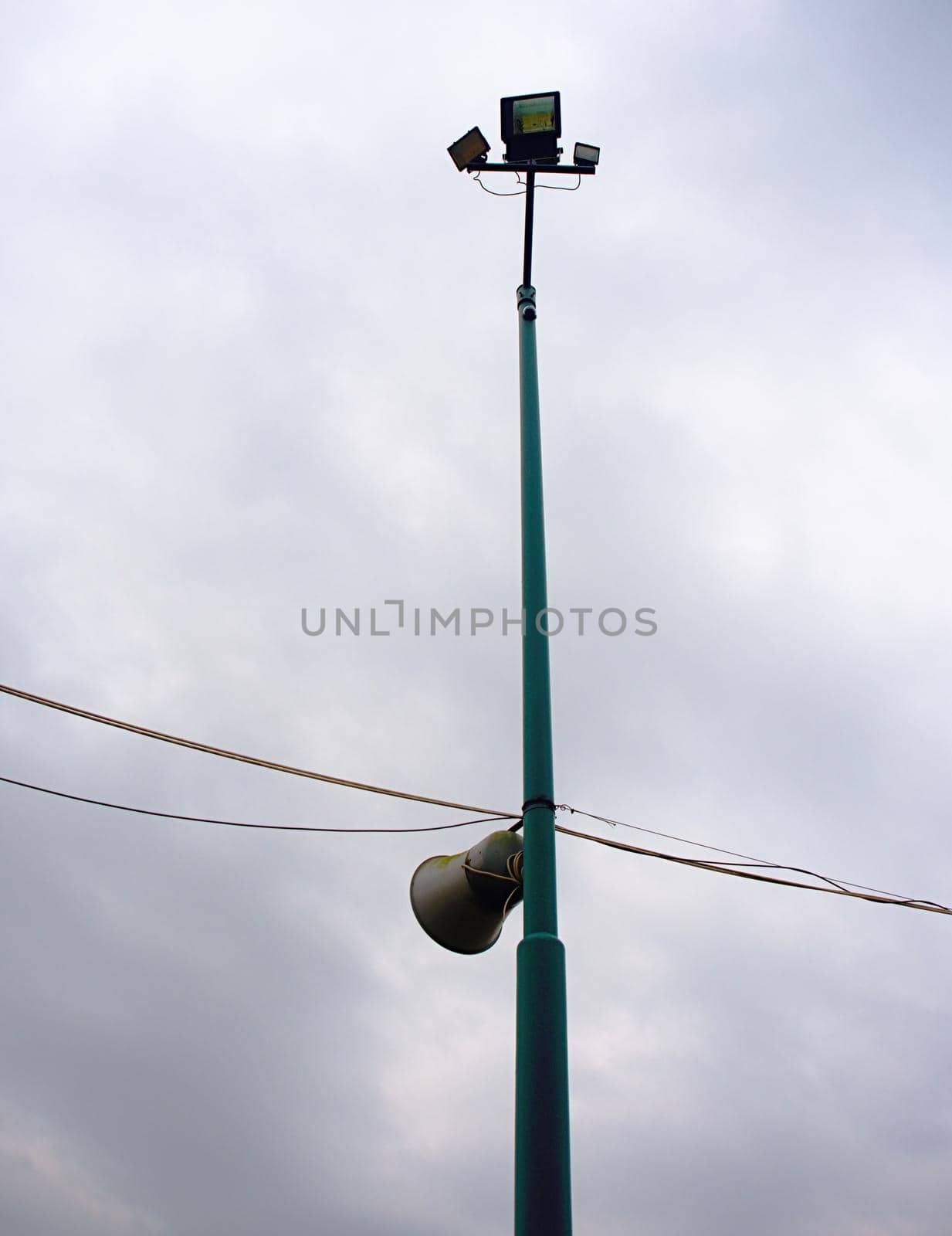Electric light pole on the background is the sky blue indigo. The stadium field light pole 