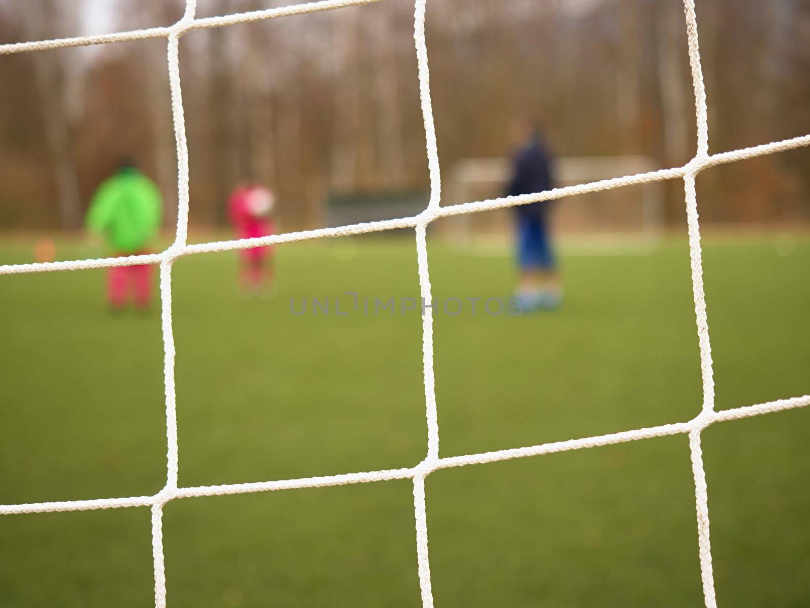 Soccer football net background over green grass and blurry stadium. Close up detail of a soccer net Footballsoccer field.  

