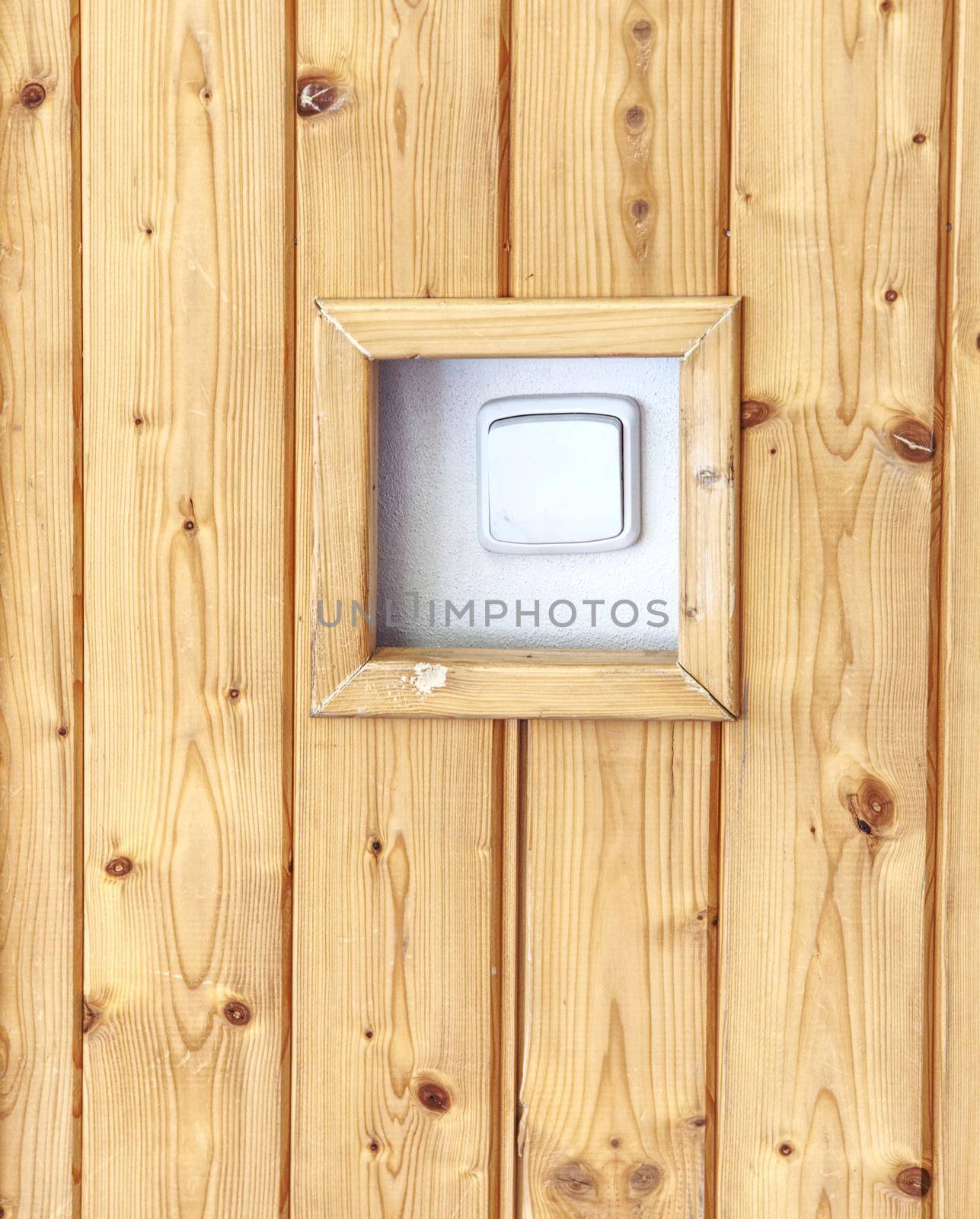 White switcher on wall. Brown wooden wall with white switch, background. Home interior decor.