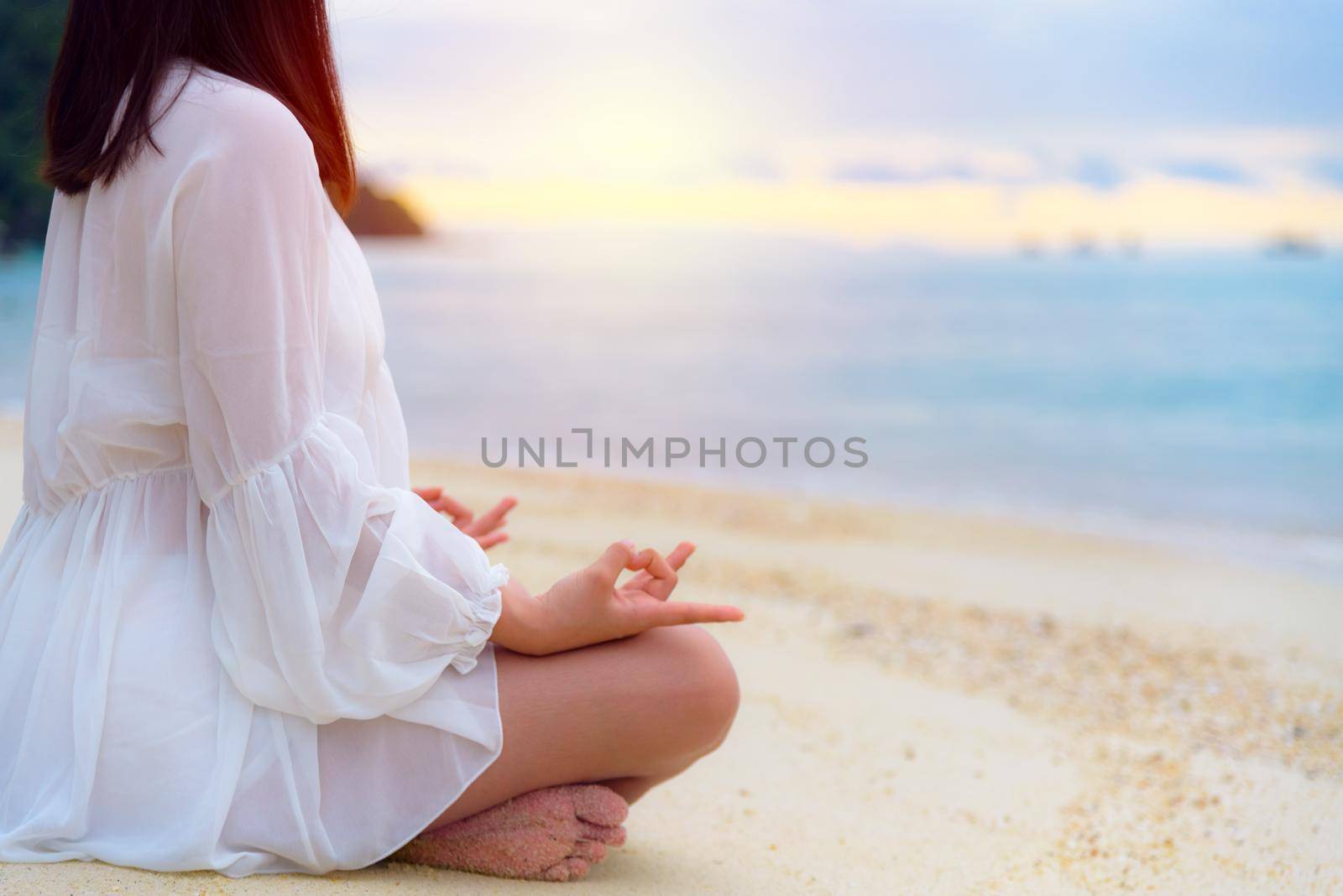 Asian young woman practicing yoga on the beach by Yongkiet
