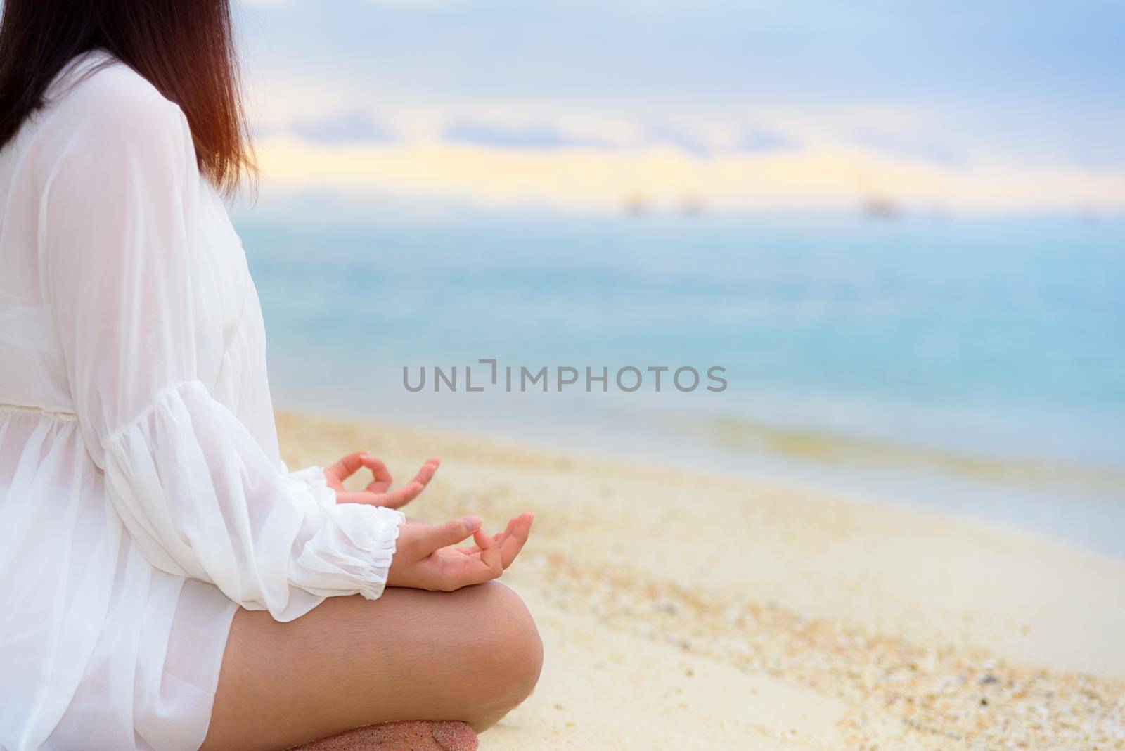 Asian young woman practice yoga on the beach near the sea under sunlight at sunrise, Relaxation for health in the midst of nature with happiness and peace, blank for the background