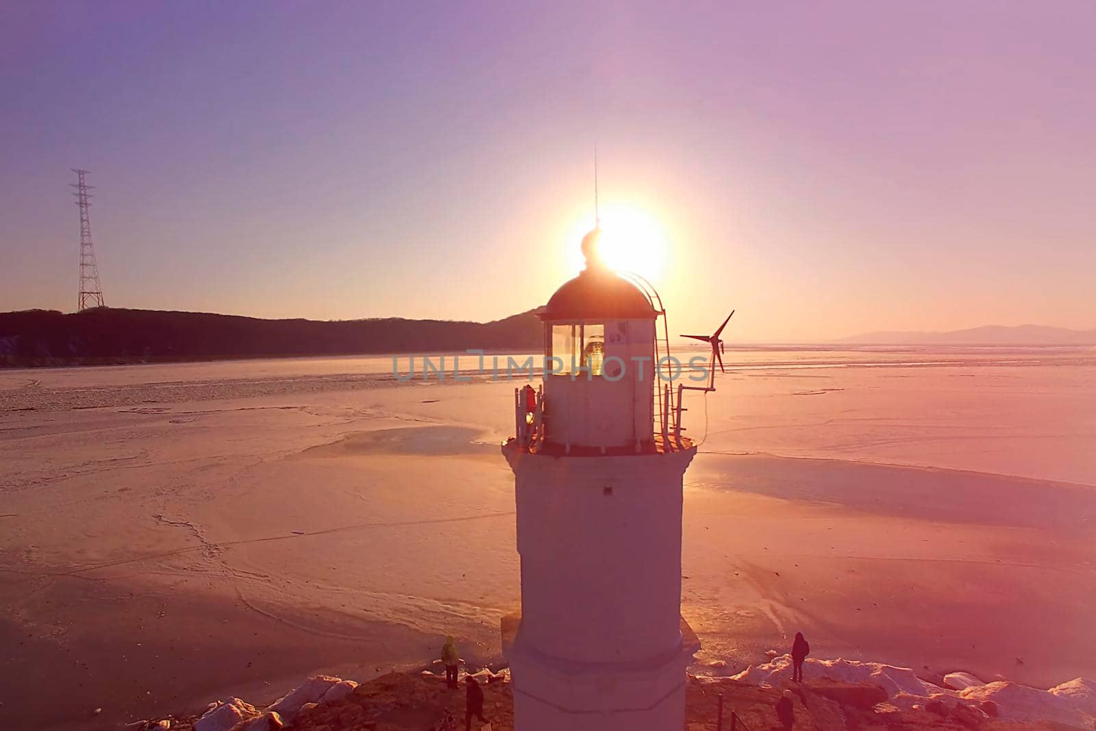 Aerial view of the pink sunset over the Amur Bay on the background of a white lighthouse. Vladivostok, Primorsky Krai.
