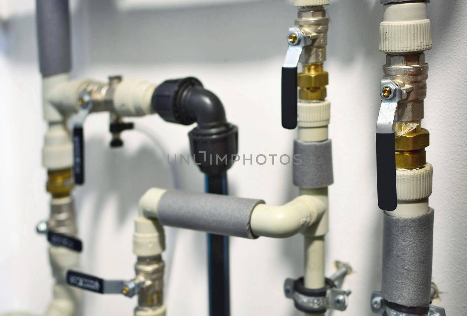 Closeup of an interior home plastic water piping with water shuts and valves on. Water pipes. Main water distribution in the home.