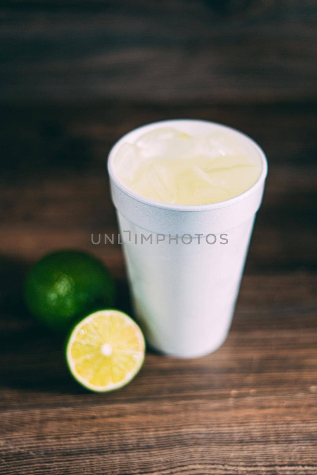 A disposable styrofoam cup and a citrus fruit