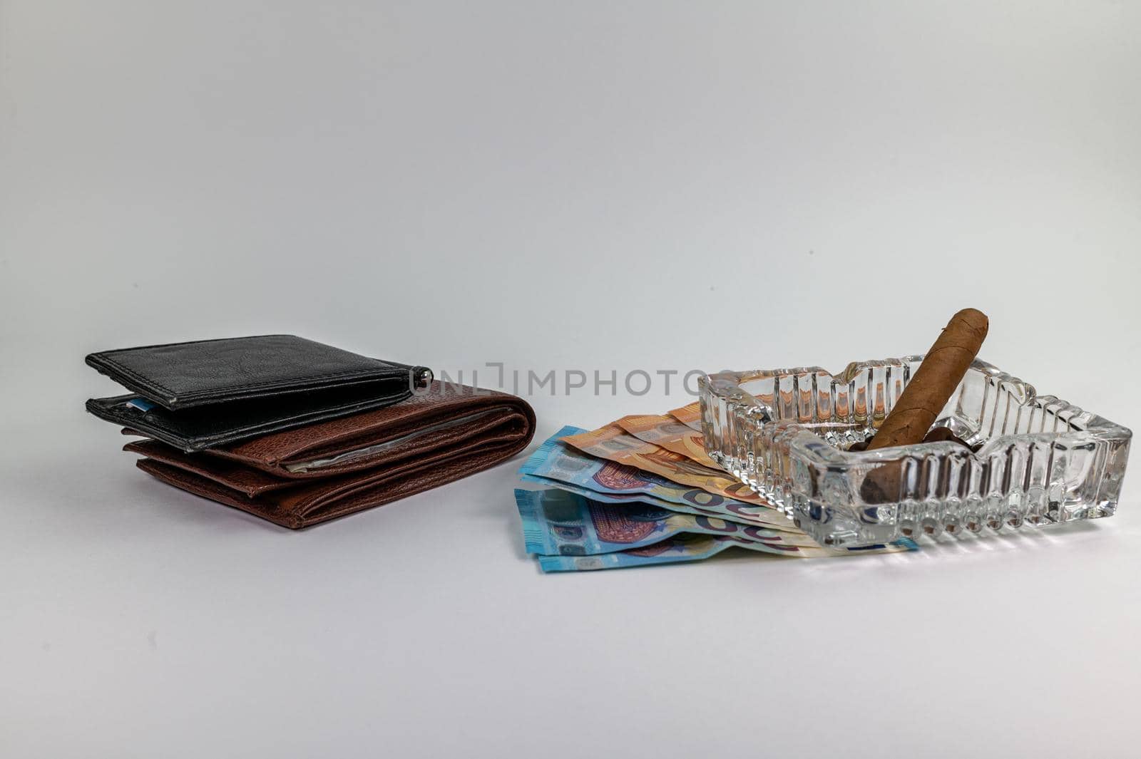 20 and 50 euro banknotes and wallet and cigar on a white background
