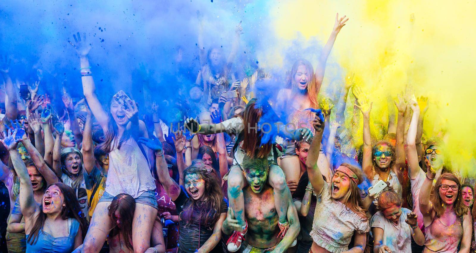 Holi colors holiday. Crazy crowd of young people having fun during festival of colors ColorFest in Kyiv, Ukraine