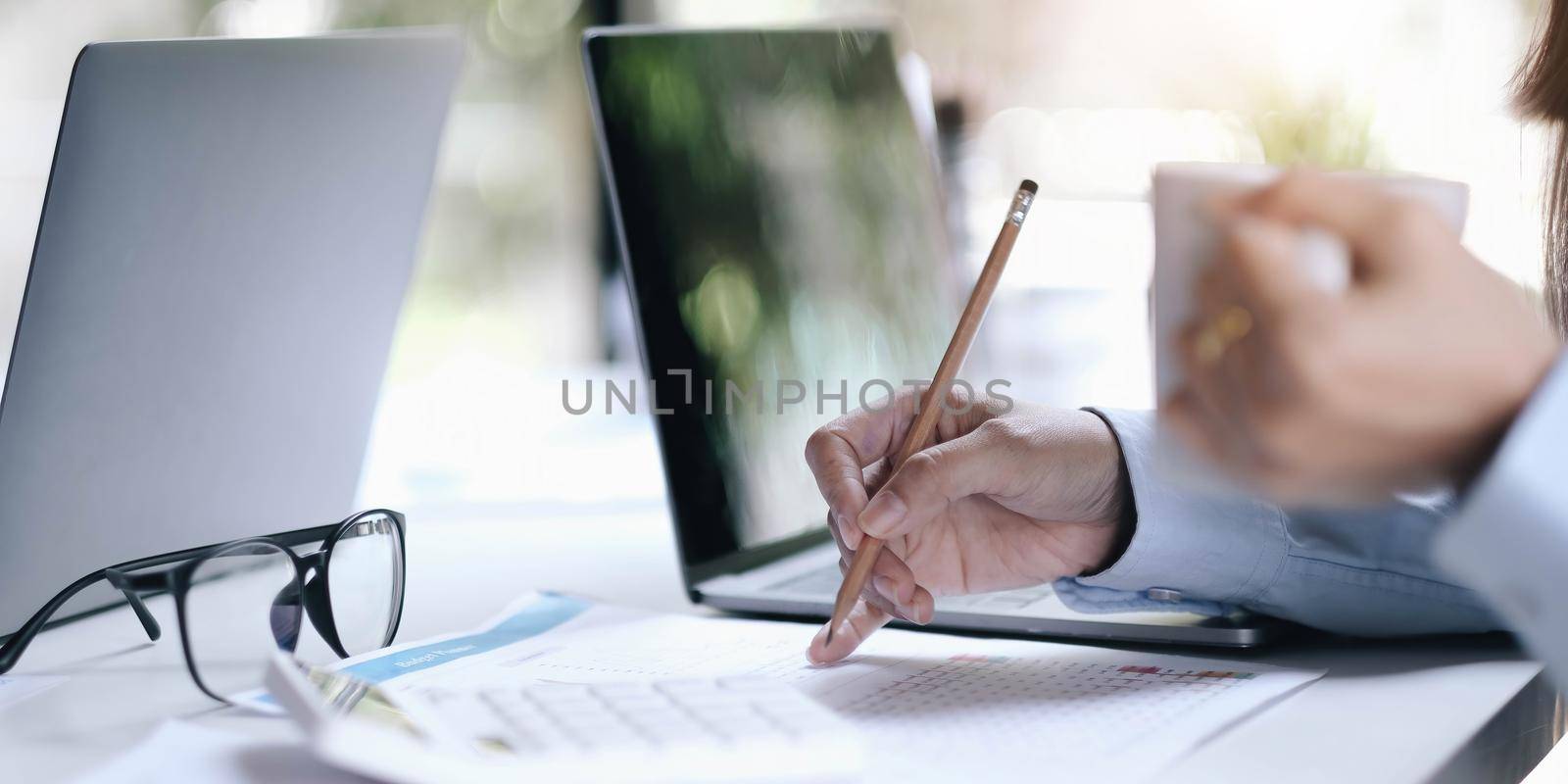 Business people hand pointing at business document during discussion at meeting..