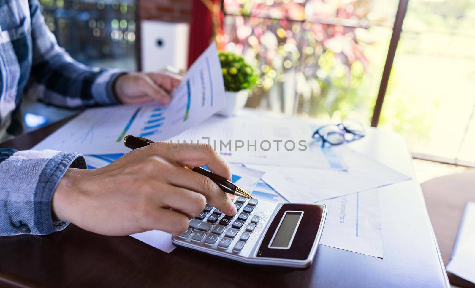 Close up, Accounting man or Entrepreneurship calculating from income report, profit statistic document, tax paper at modern office.