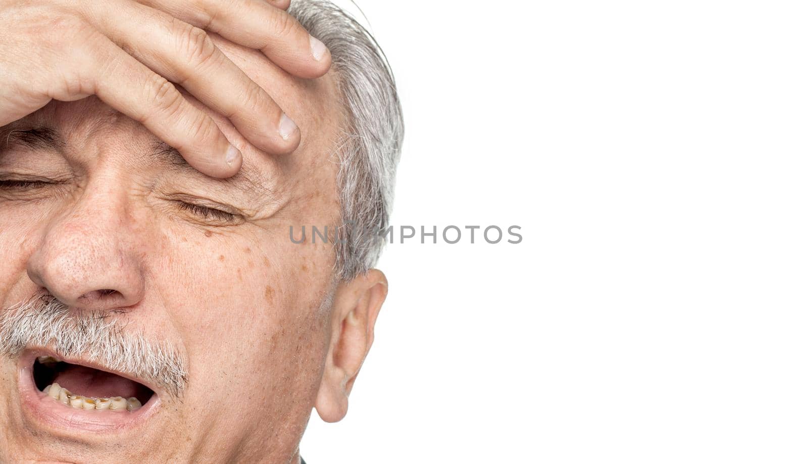 Pain. Elderly man suffering from a headache isolated on white background with copy-space
