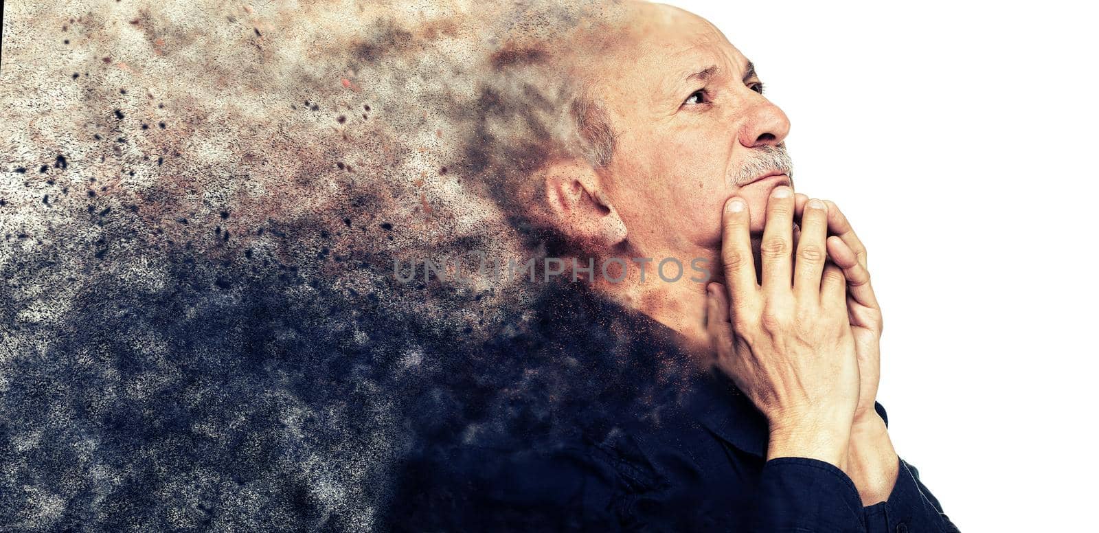 Elderly man with hands near his face looking up thinking