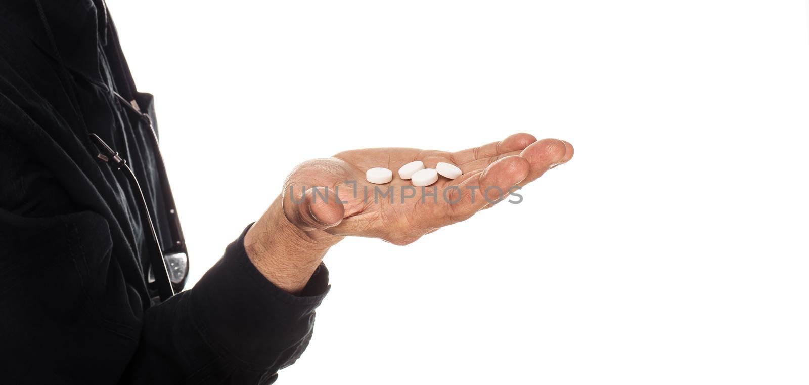 Medicine and health concept. Hand of an elderly man with pills on a white background. Old man wants to take a pill