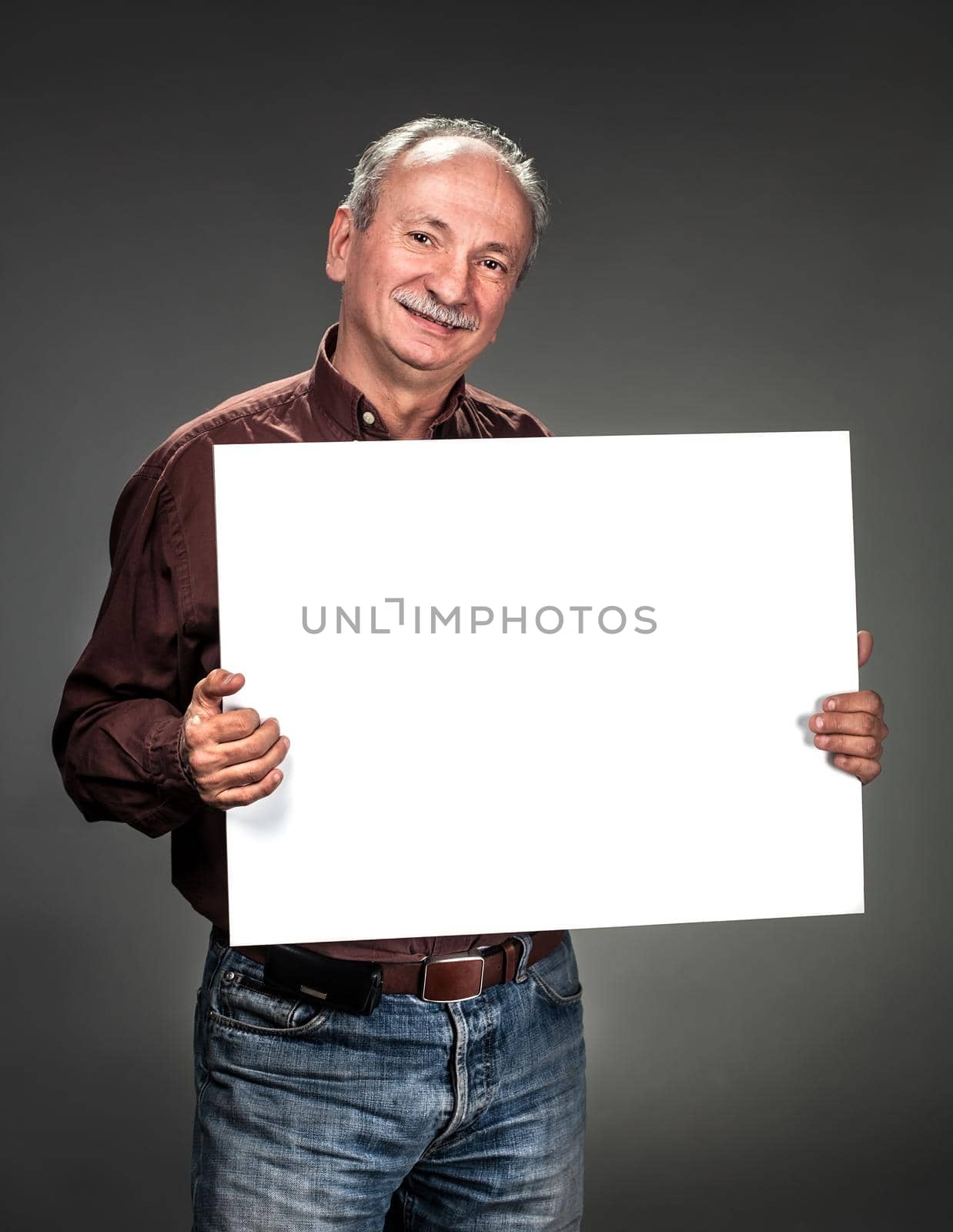 An elderly man holding a blank billboard