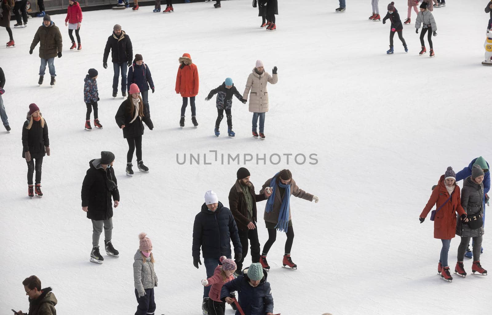KYIV, UKRAINE - Dec. 27, 2020: Ice-skating people. People have fun in ice arena at the city ice rink. New Years holidays in city Kyiv.