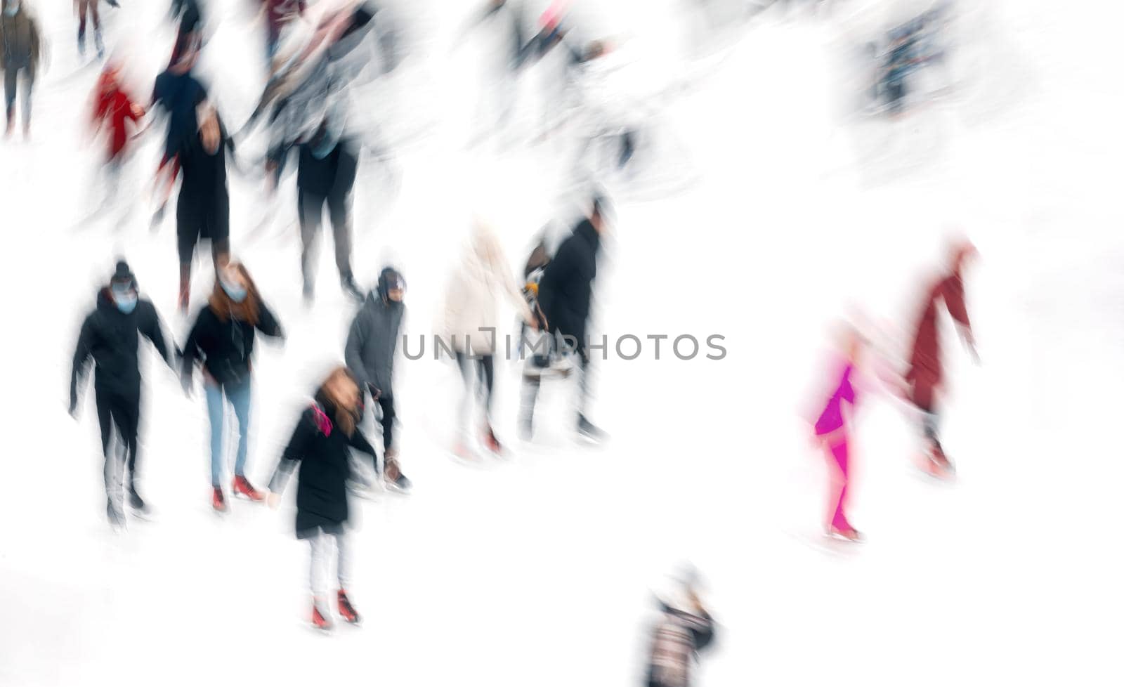 Motion blurred abstract image of people skating on an ice rink. Ice-skating people.