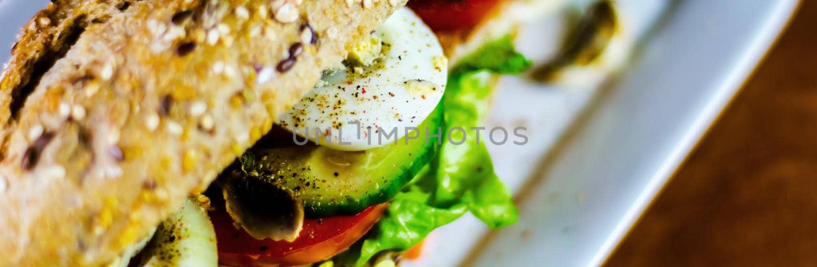 Whole grain sandwich with ham, tomato, mushrooms and egg, fresh organic vegetables, healthy food
