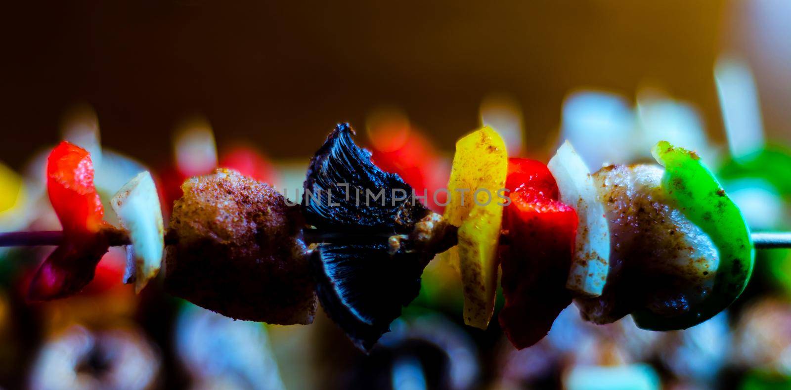 skewers with meat and vegetables prepared for grilling on a wooden board, colorful and tasty dish