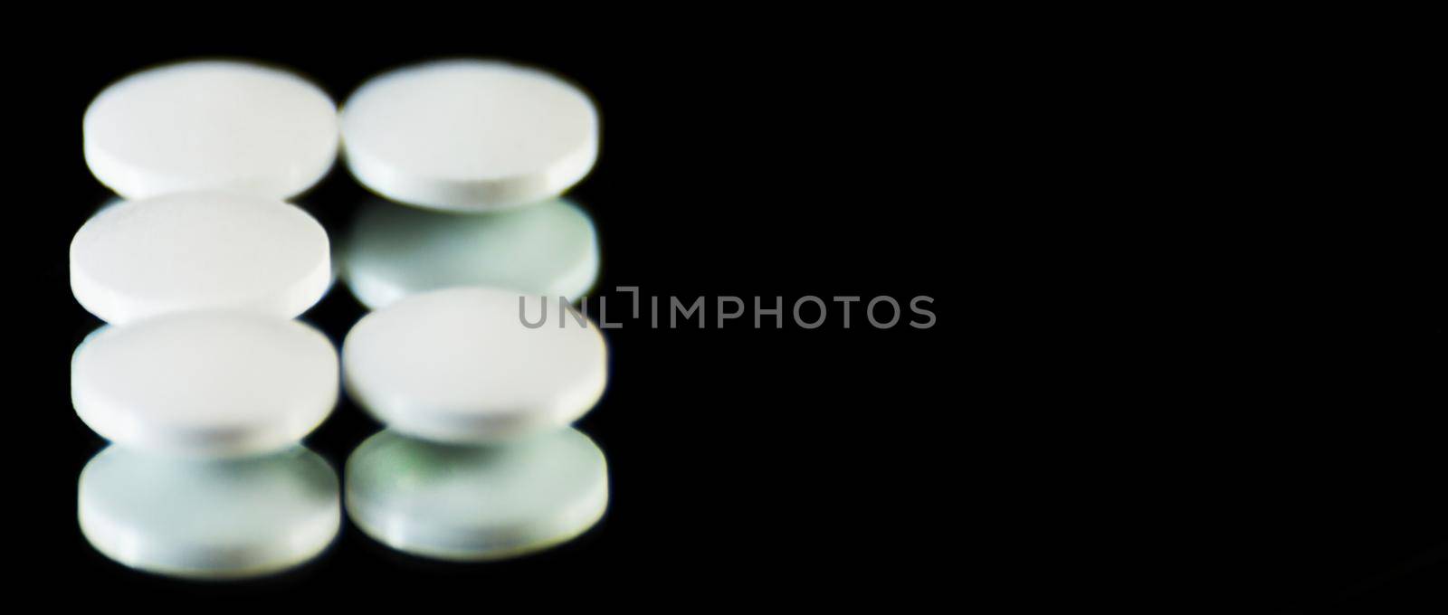 scattered tablets on a black background, pills reflected in the mirror, medicine