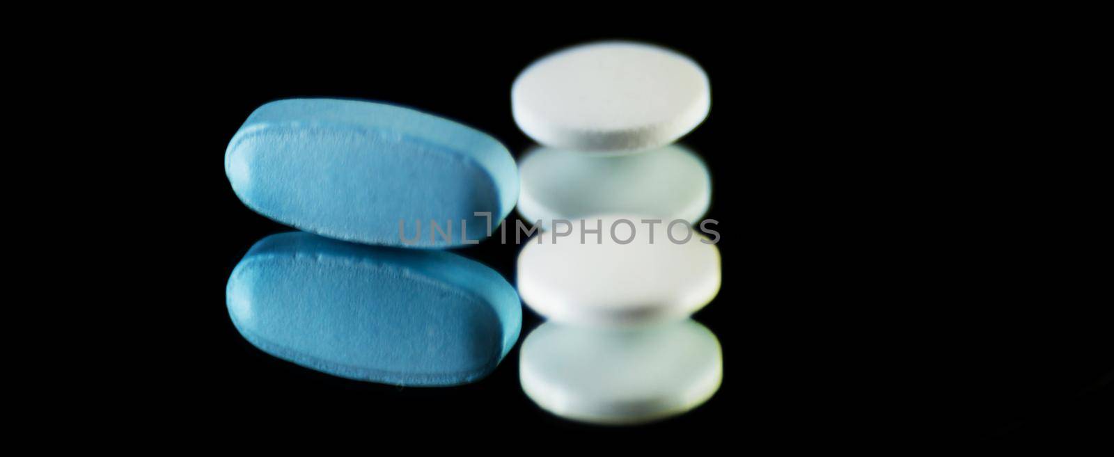 scattered tablets on a black background, pills reflected in the mirror, medicine