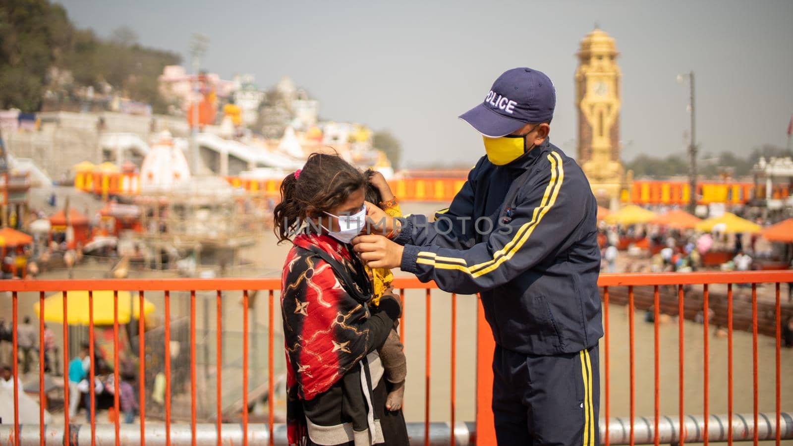 Policemen wearing protection mask to a child to stay safe from Coronavirus during Maha Kumbh 2021 by stocksvids