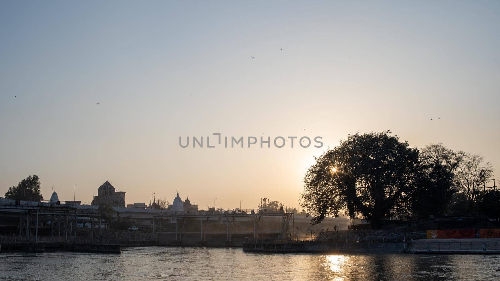 Sun, clouds, Tree and Holy River Ganges scenery haridwar Uttarakhand India . High quality photo