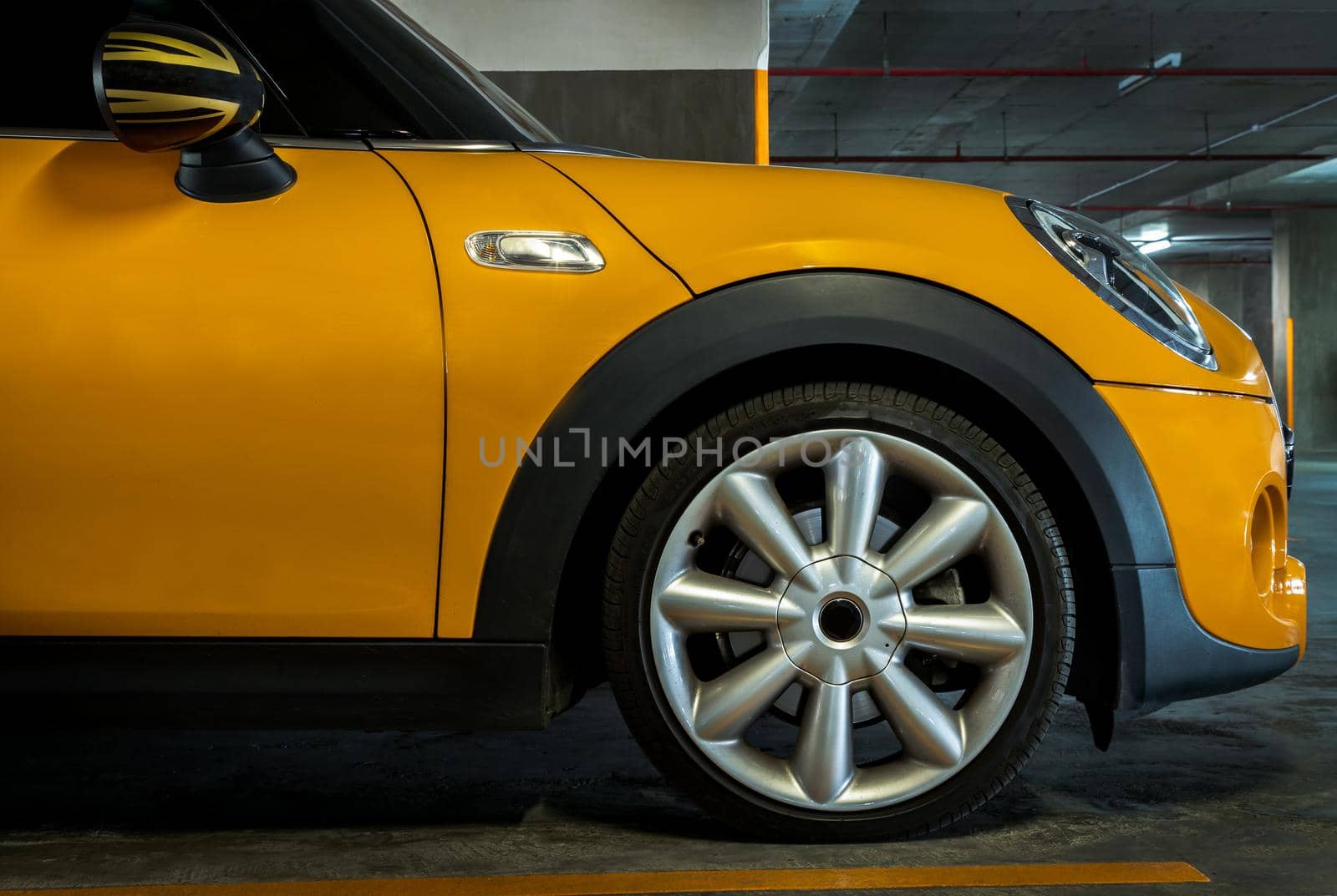 Bangkok, Thailand - 27 May 2021 : Side view of Headlights, Wheel, Hood, Sidelights and Side view mirror of Yellow car. Selective focus.