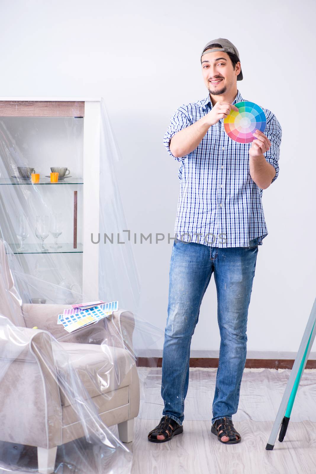Young man contractor choosing color from rainbow 